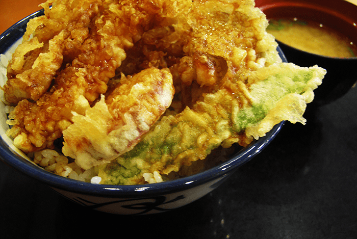 Plat japonais de beignets de crevettes et de légumes frits sur un bol de riz
